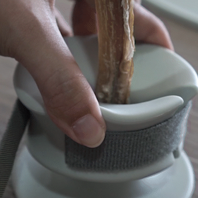 2.【ぎゅっと締める】 ぎゅっと押しながら、周りのストラップを締めおやつをしっかりと固定する。