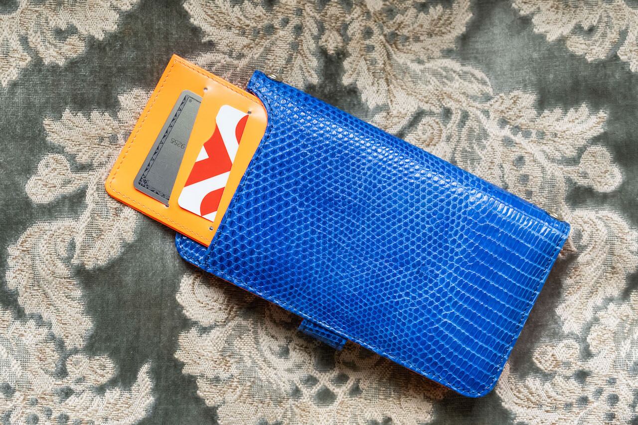 背面のポケットには同じくオレンジのケース付き。免許書や名刺、カードキーが入れられる。