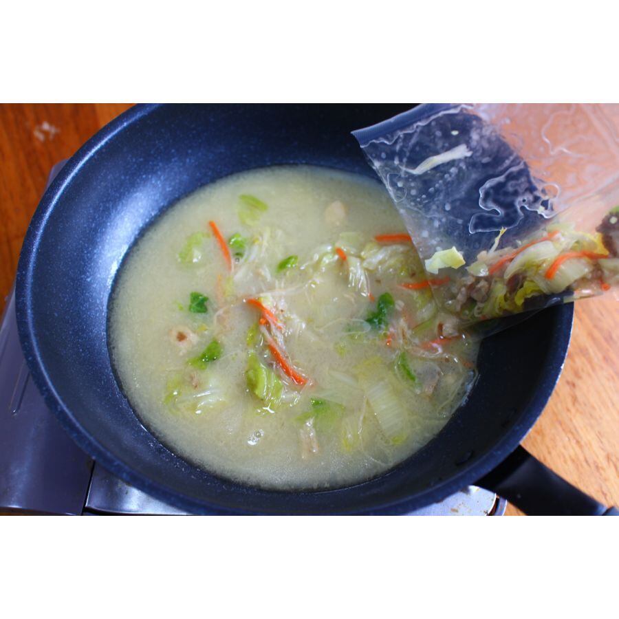 鍋に溶けたスープと野菜の袋を開けて入れる