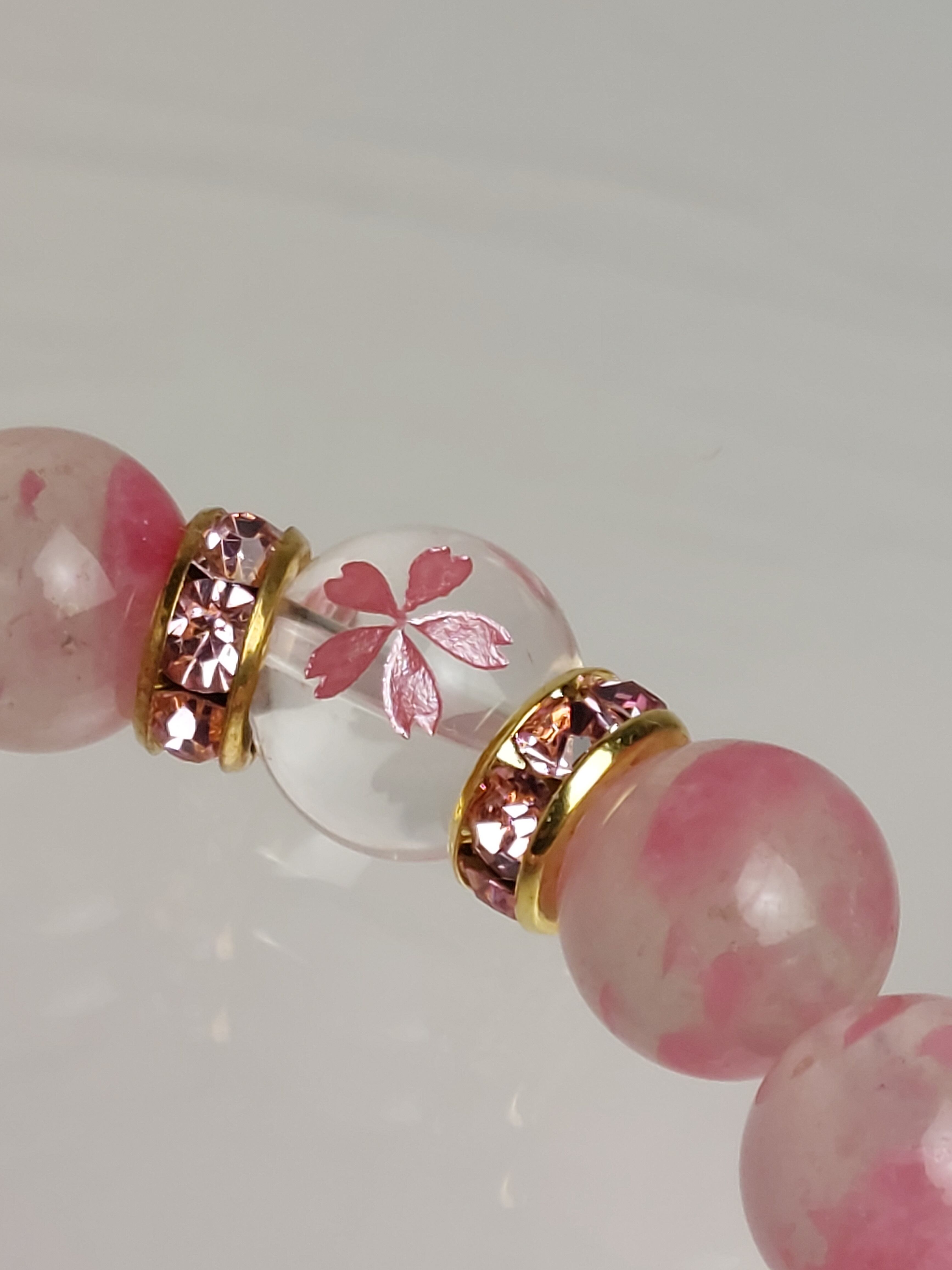 桜が彫刻された水晶とロードナイトを合わせて制作しています。