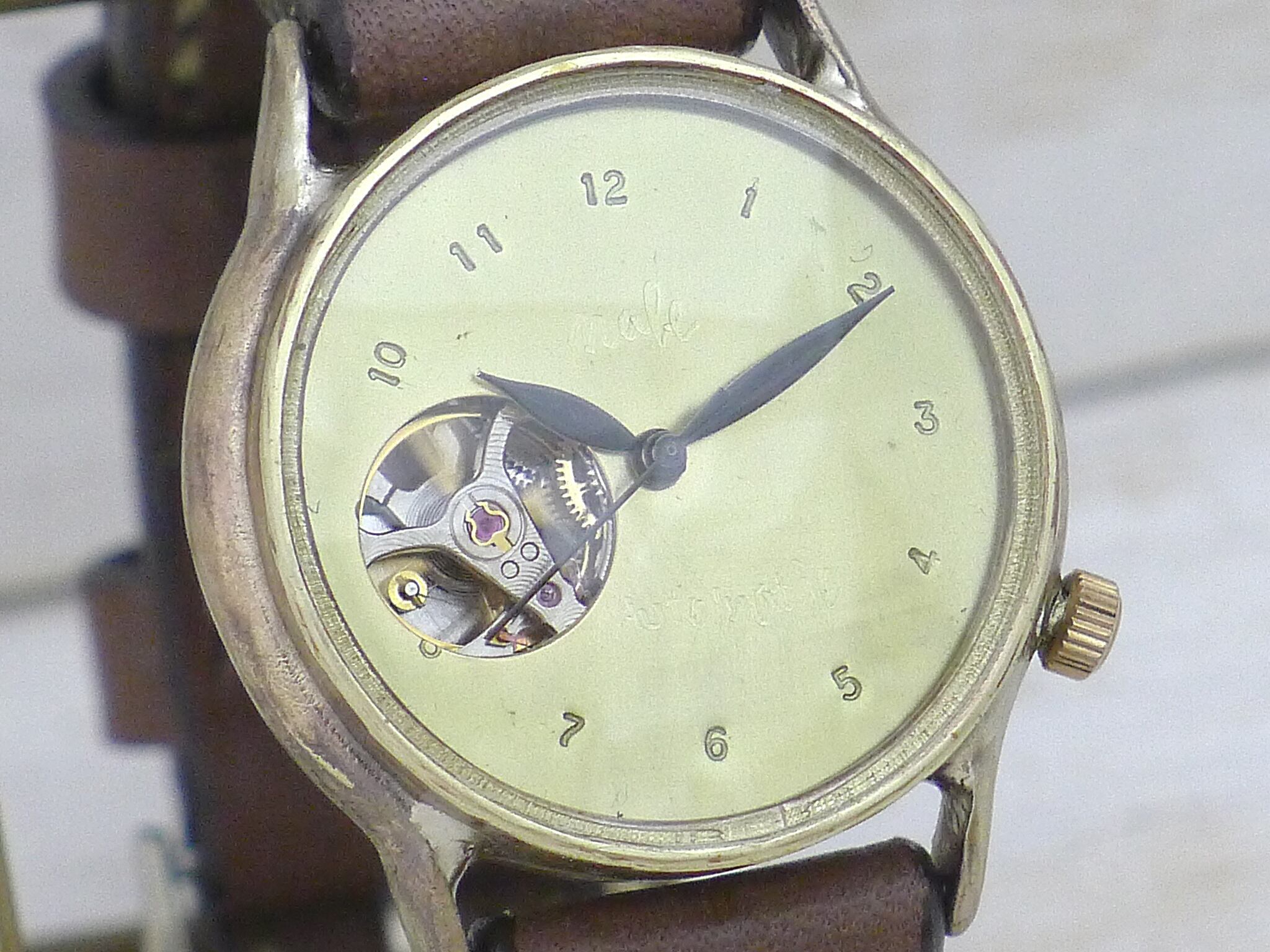 ムーブメントの一部(テンプ)が覗くオープンハートタイプ