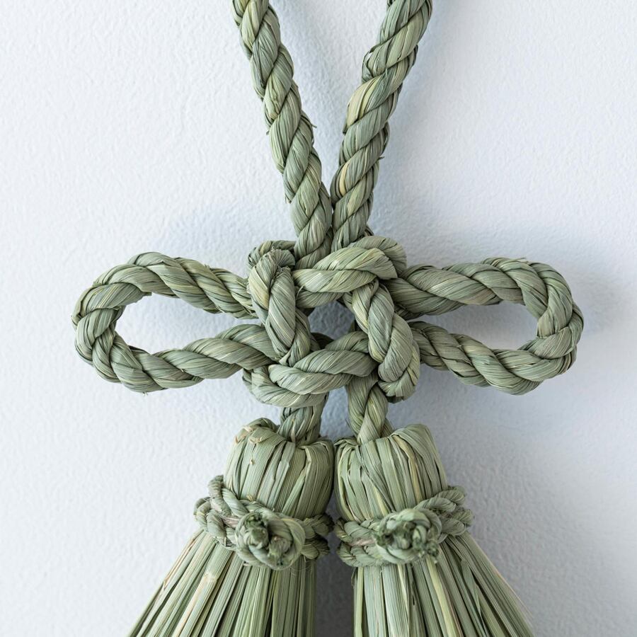 総角（あげまき）結びと言われる日本古来の結びを稲わらの縄で表現。