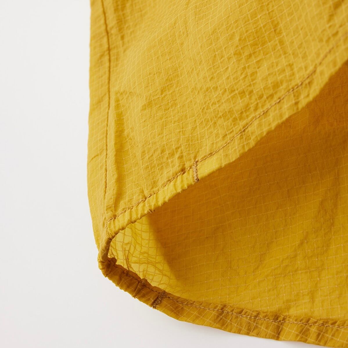 裾はクライミング中のずり上がりを防ぐために、あえてルーズフィット。両サイドに短いコールゴム