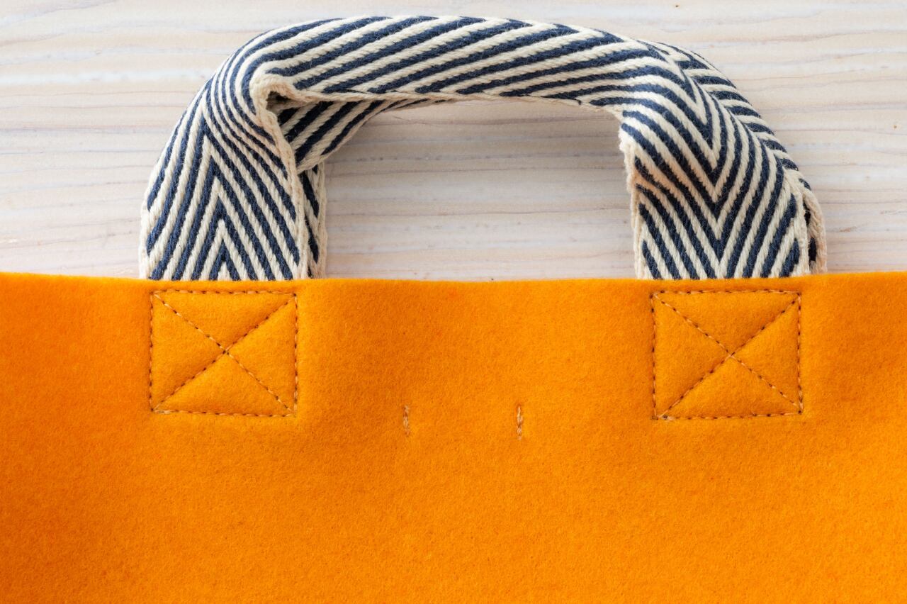 反対側にはブランドタグを留めた縫い目が見えます。