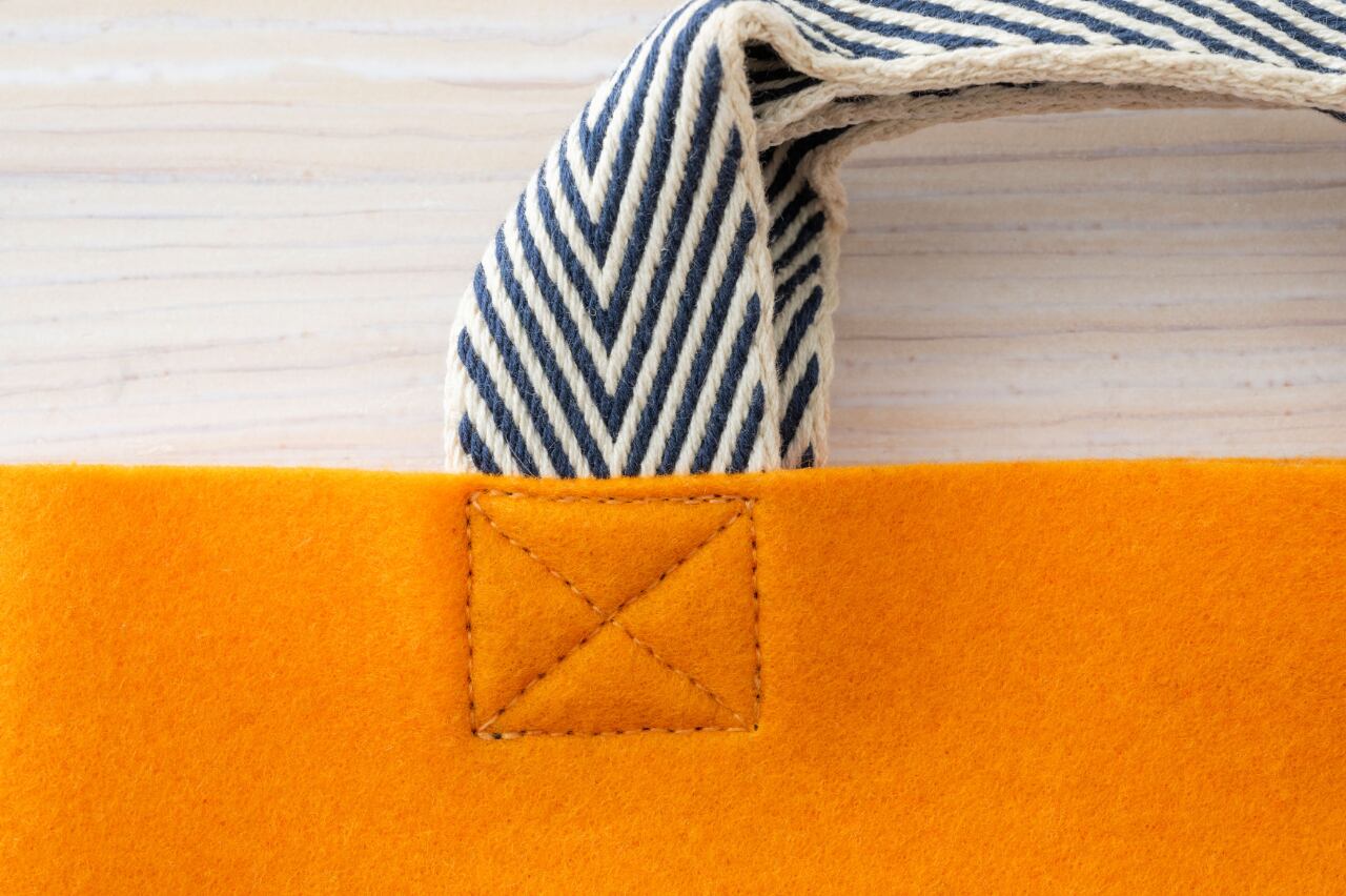 持ち手の留めはしっかり縫製。羊毛フェルトのような風合いです。