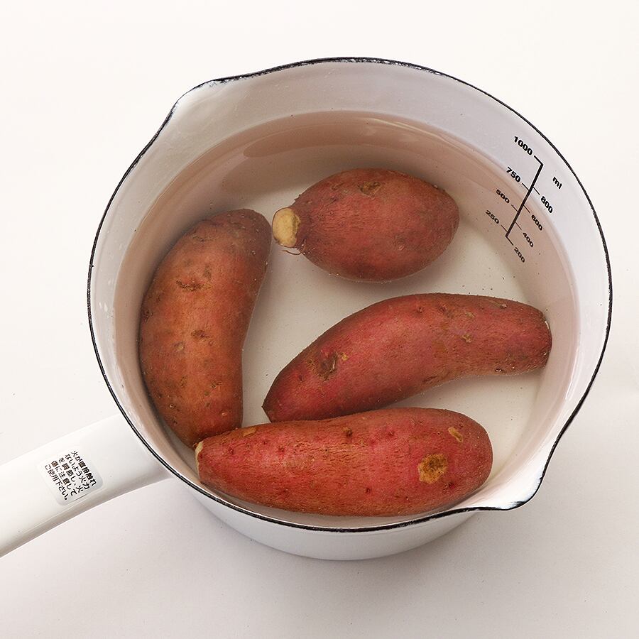 安納芋の両端を少しカットして、水に漬けます（アク抜き）。この時、塩を少々入れて約1時間浸します。