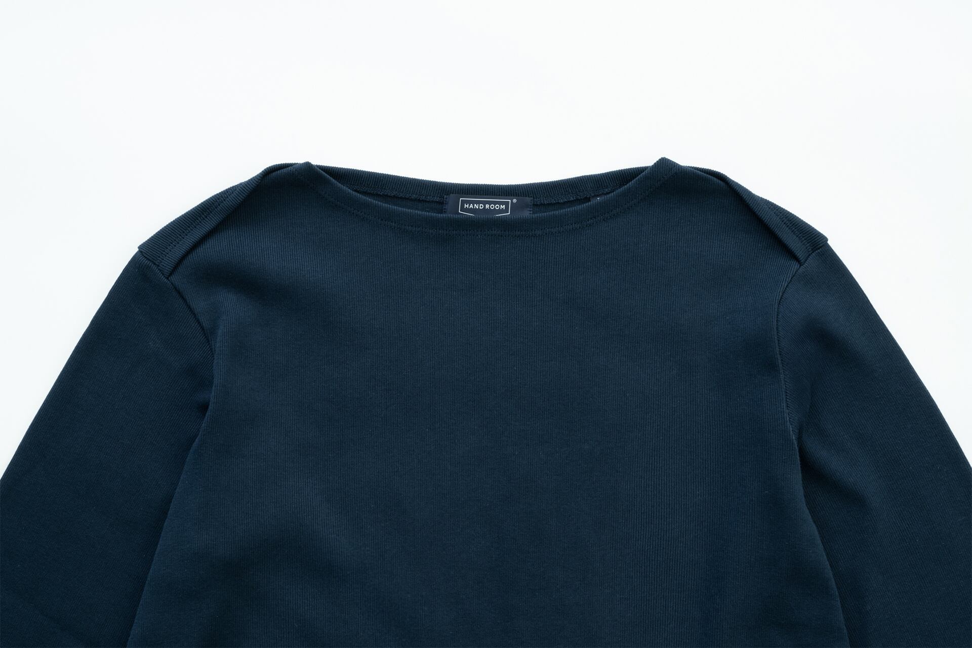 鋭角で洗練されたデザインのボートネック。肌が見えすぎず上品な印象に