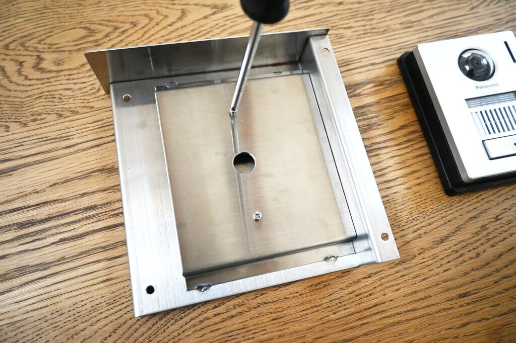 ②子機取り付け用のカバーを取り外し、2カ所のネジを外します