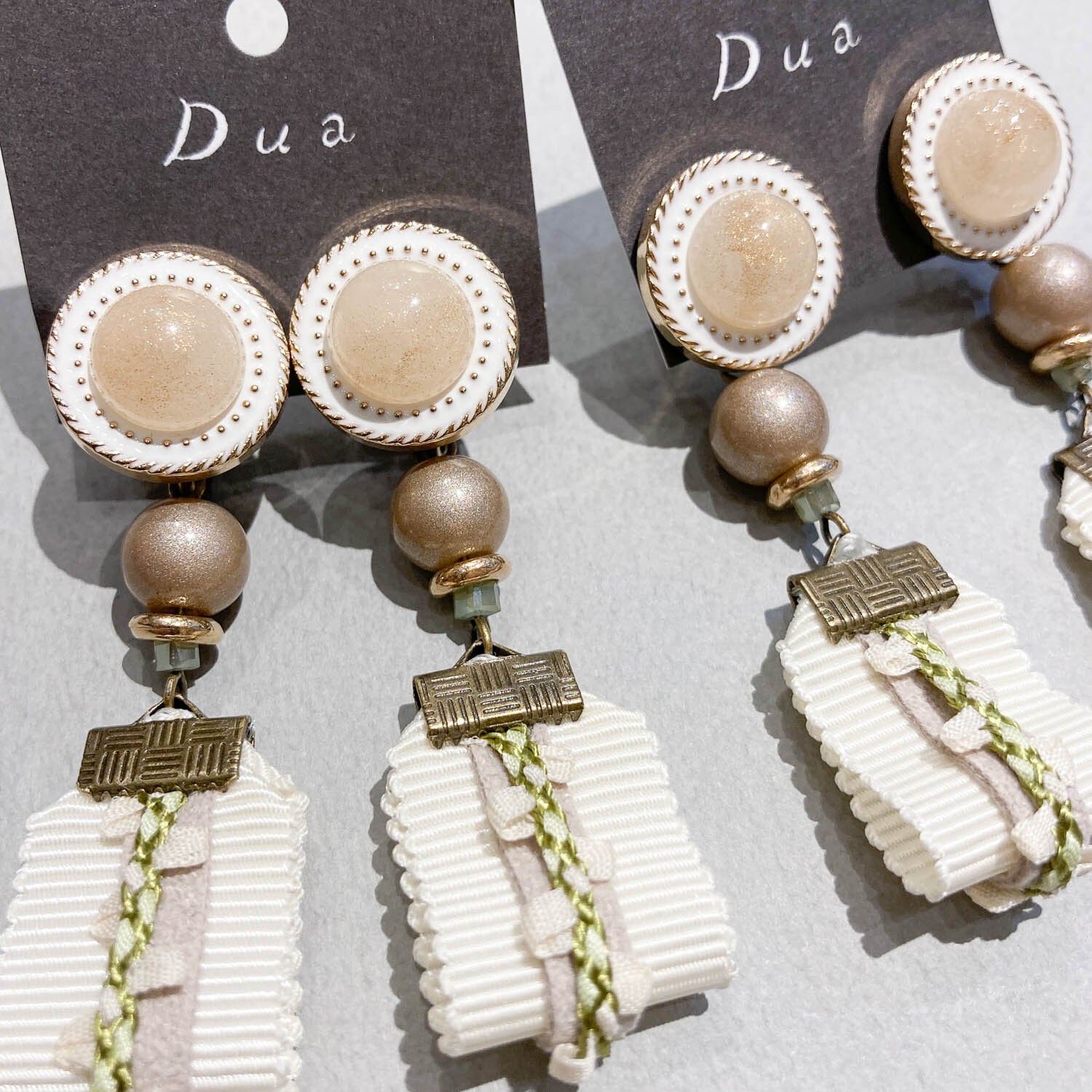 カボション貼付ボタンと重ねリボンの〈ピアス/イヤリング〉 | Dua
