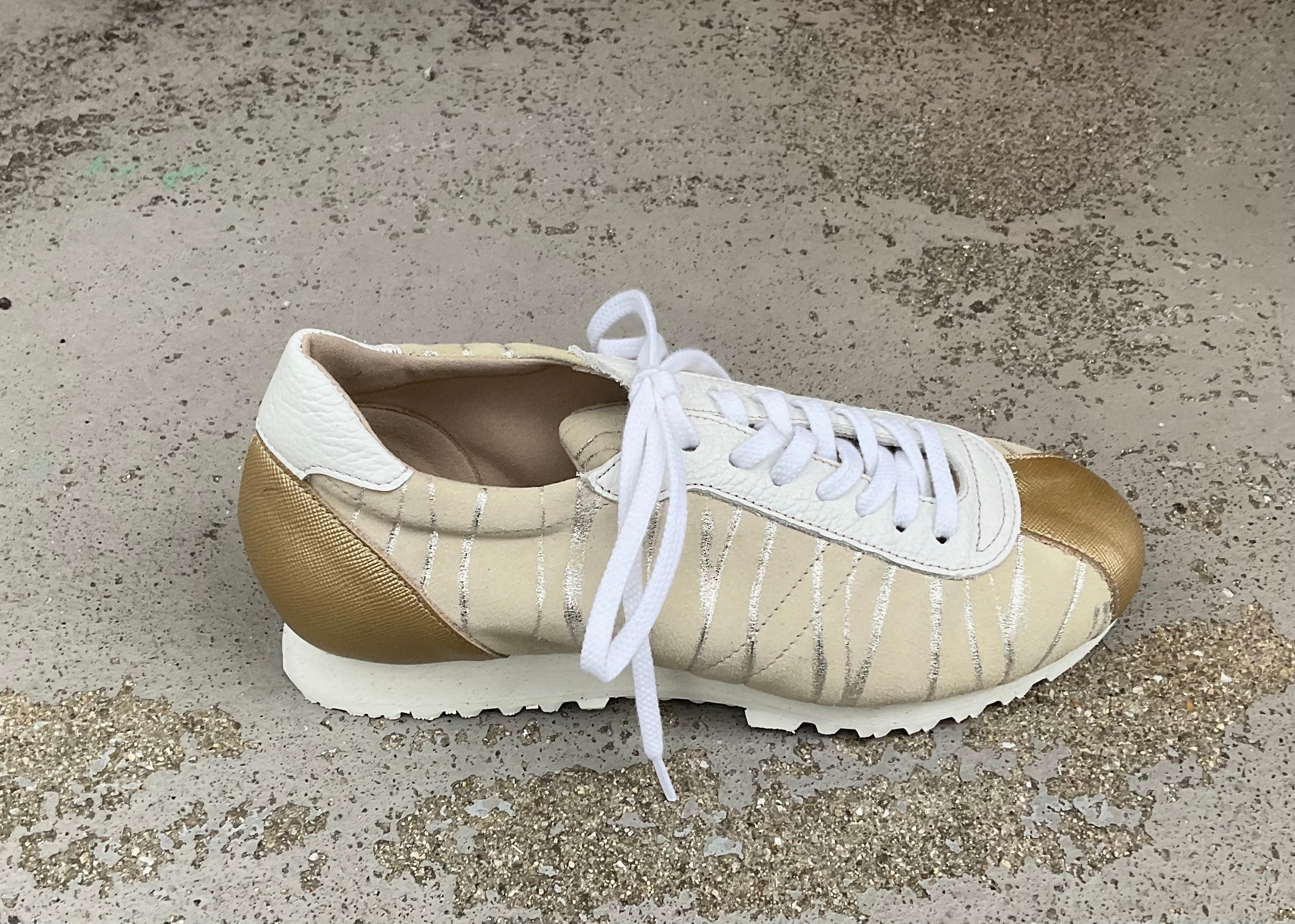 シャンパンゴールドが上品に輝くレザースニーカー｜大人カジュアルに