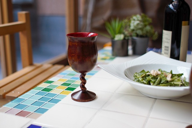 漆塗りのワイングラスの載ったテーブルの写真
