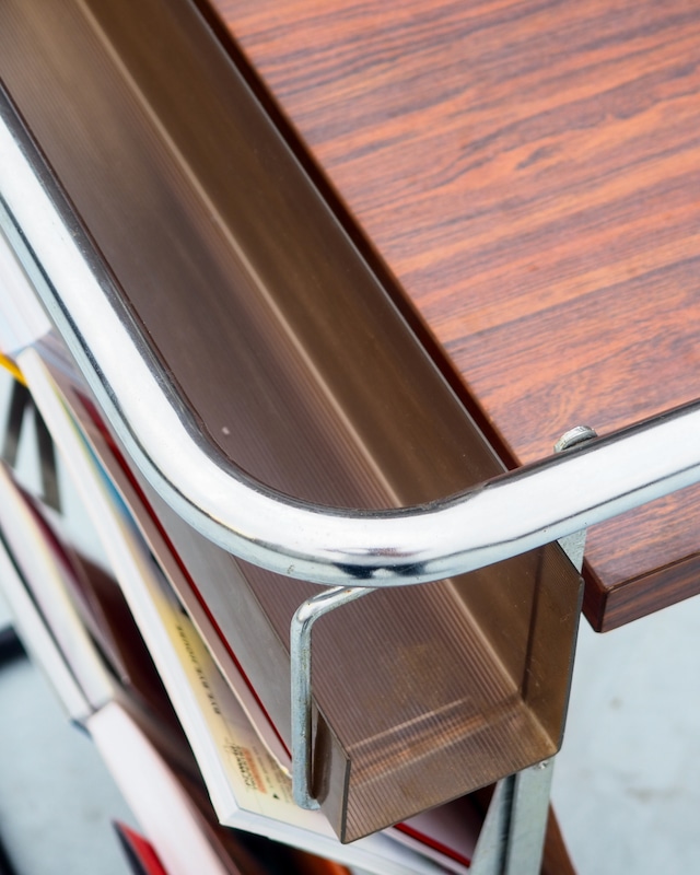 Table with foldable magazine rack, storage compartment, and towel rack