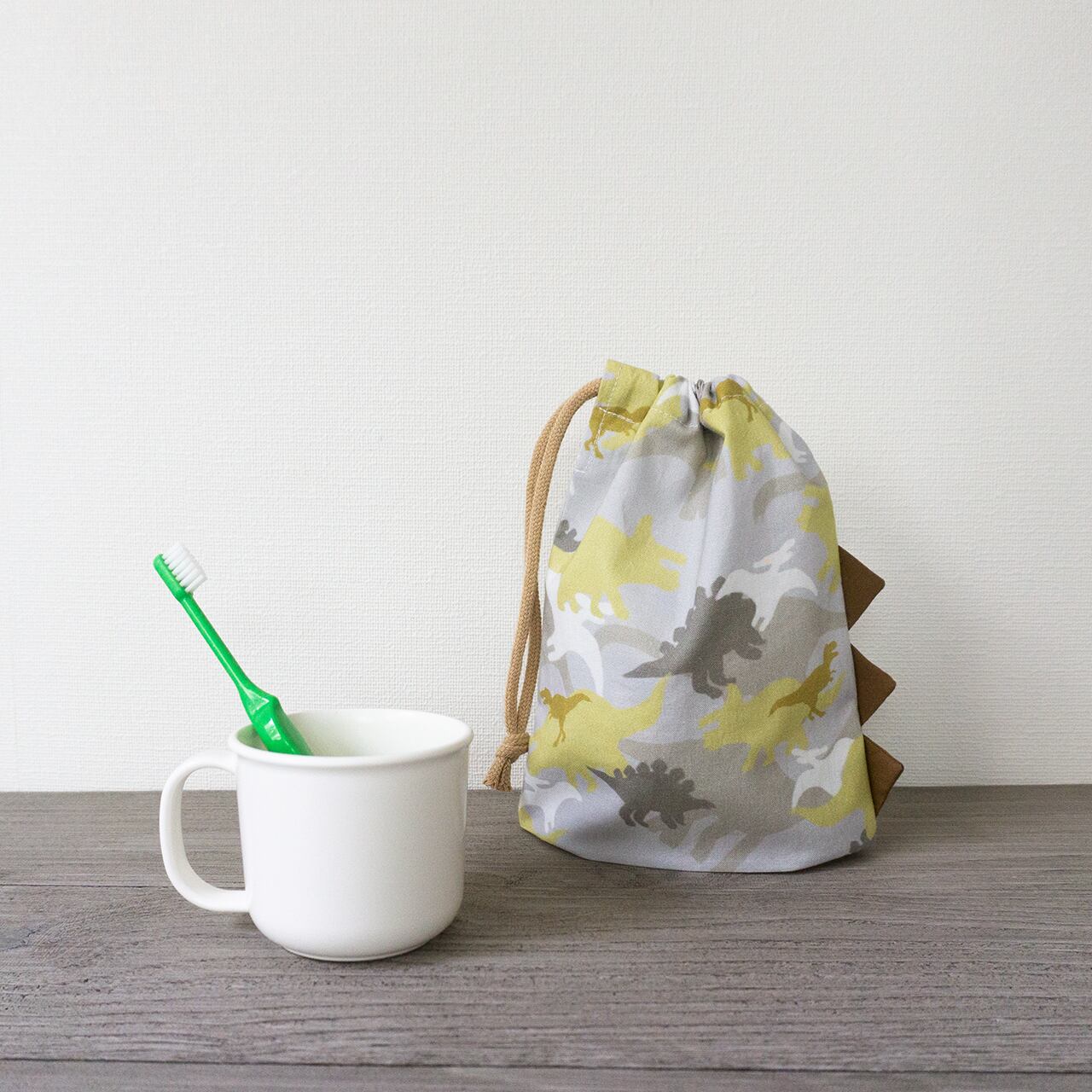よく見ると恐竜な迷彩柄」コップ袋 歯ブラシホルダー付 巾着 | nicori