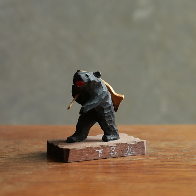 威勢よく魚を背負う、小さなクマ