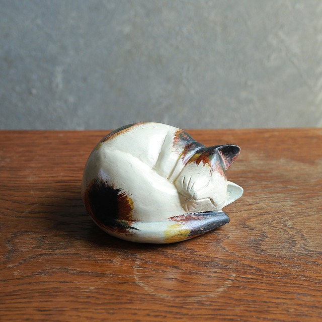 丸まって、幸せそうに眠るネコ