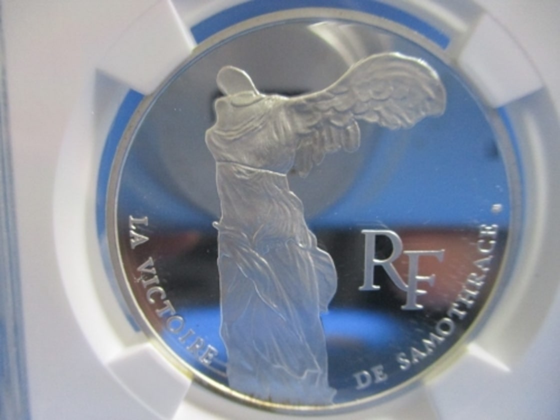 銀製コイン 都市風景と鷲のエンブレム 金、銀、プラチナ、パラジウムから選ぶ - 野口コイン