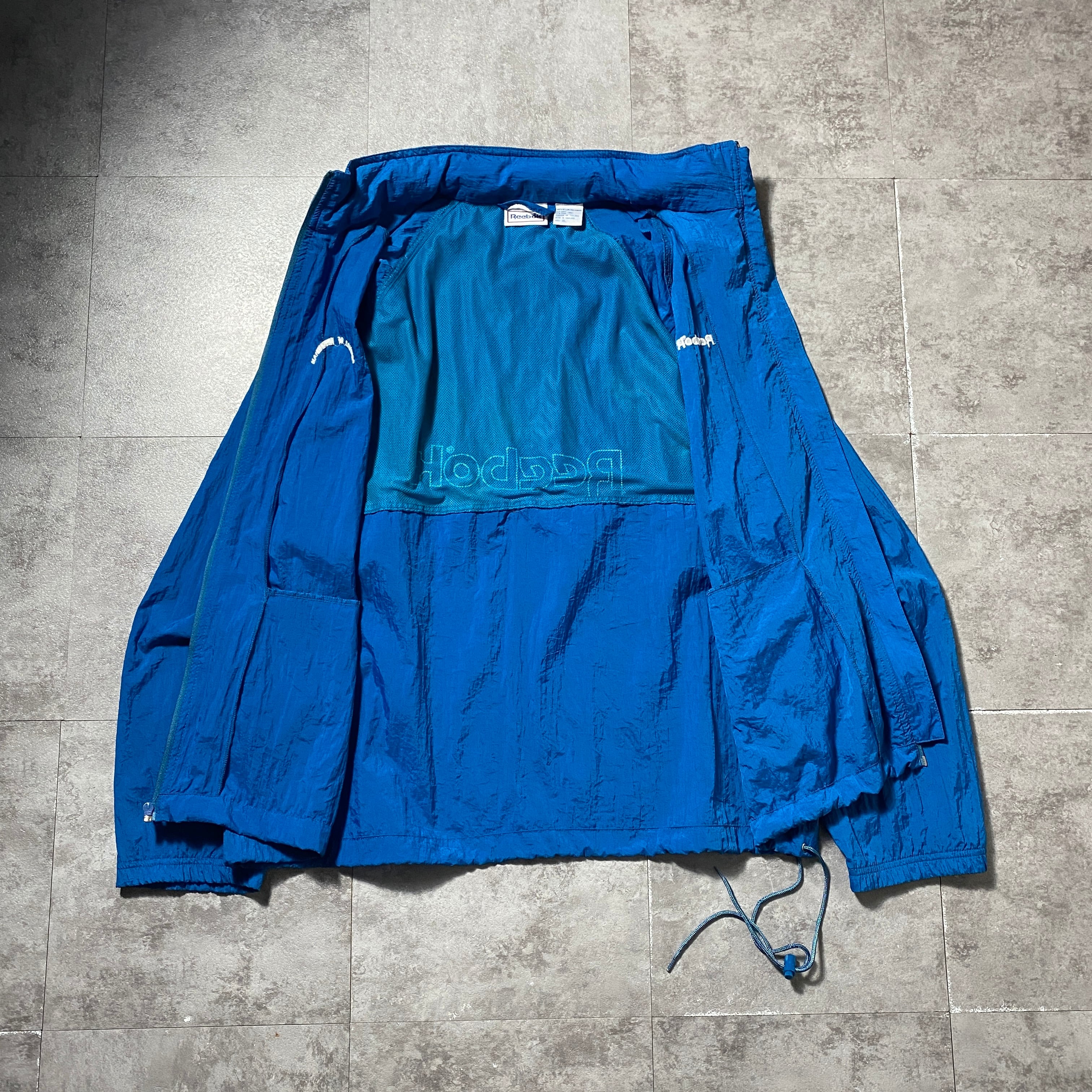 90's Reebok リーボック 両面刺繍 フード格納 ブルー 薄手 ナイロン