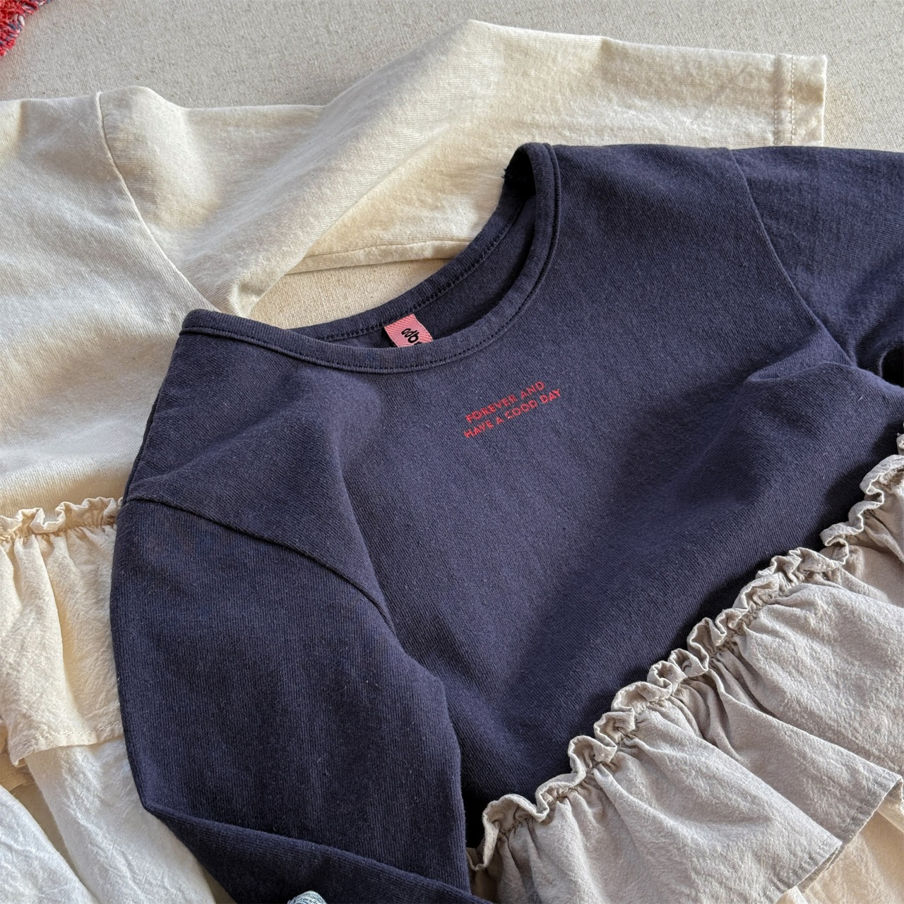 秋英字柄フリル裾Tシャツ