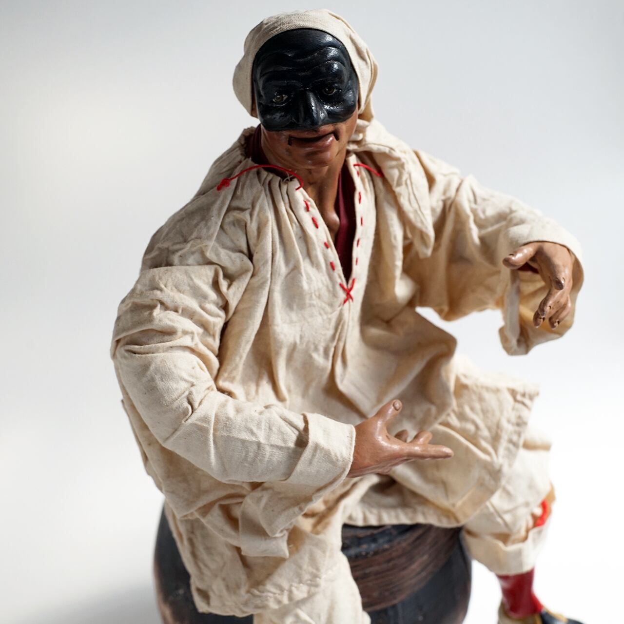 ナポリの幸運のお守り！フィアスコを持ってワイン樽に座るプルチネッラ