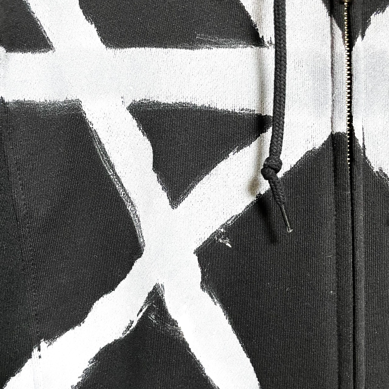 UNFINISHEDアシンメトリーペイントロングスリーブパーカー