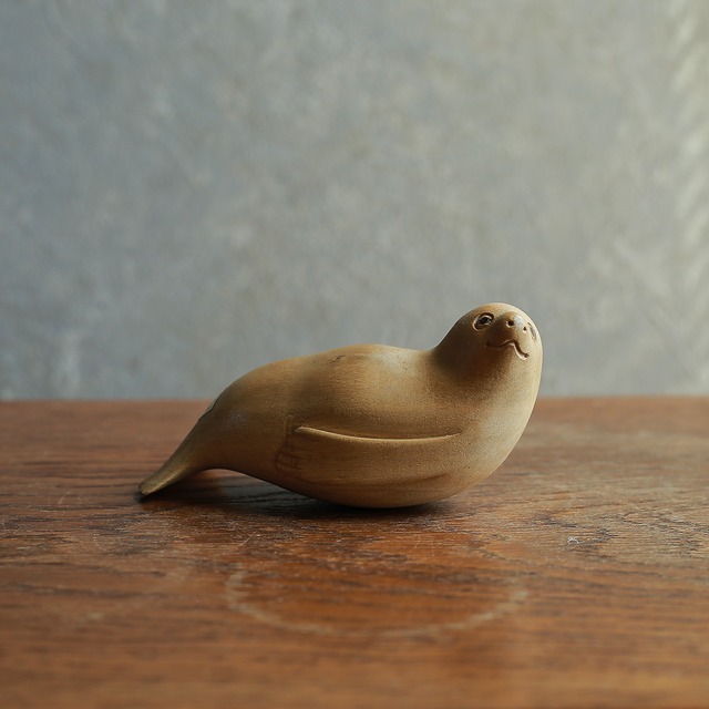 遠くを見つめて微笑む、木彫りのアザラシ
