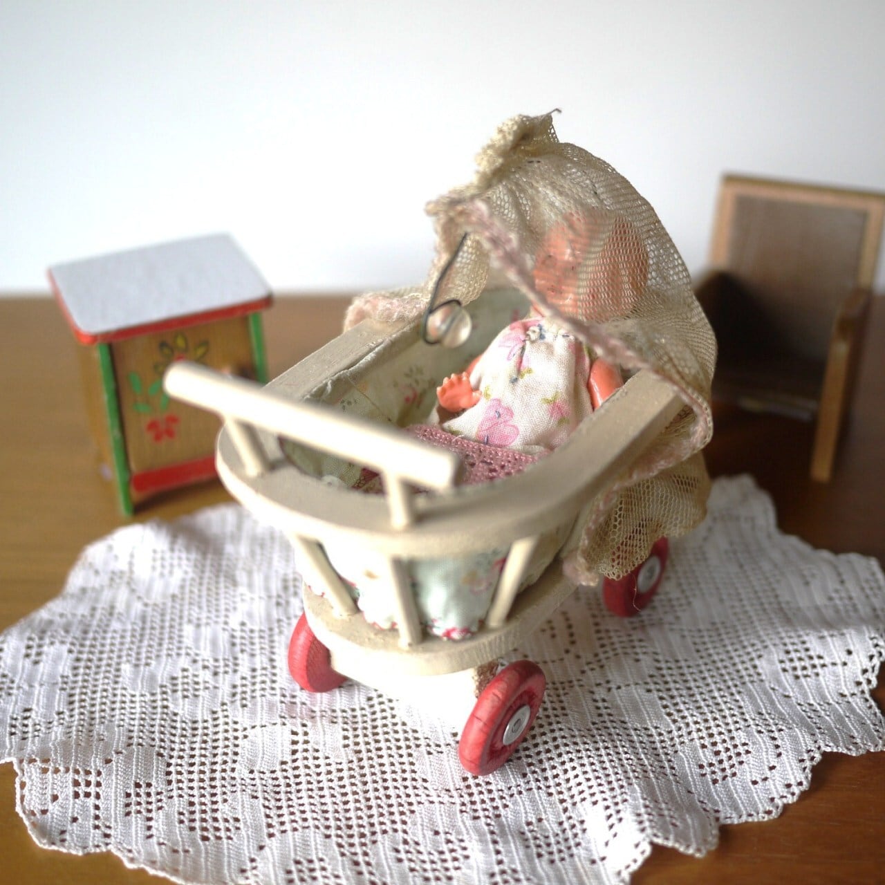 ホロ付き木製ベビーカーと花柄ベビー服