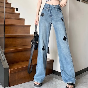 cross design wide leg denim pants with mark la1581