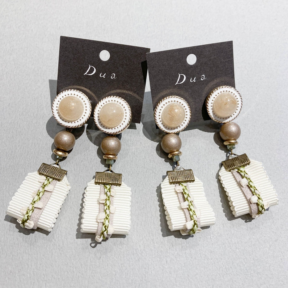 カボション貼付ボタンと重ねリボンの〈ピアス/イヤリング〉 | Dua 