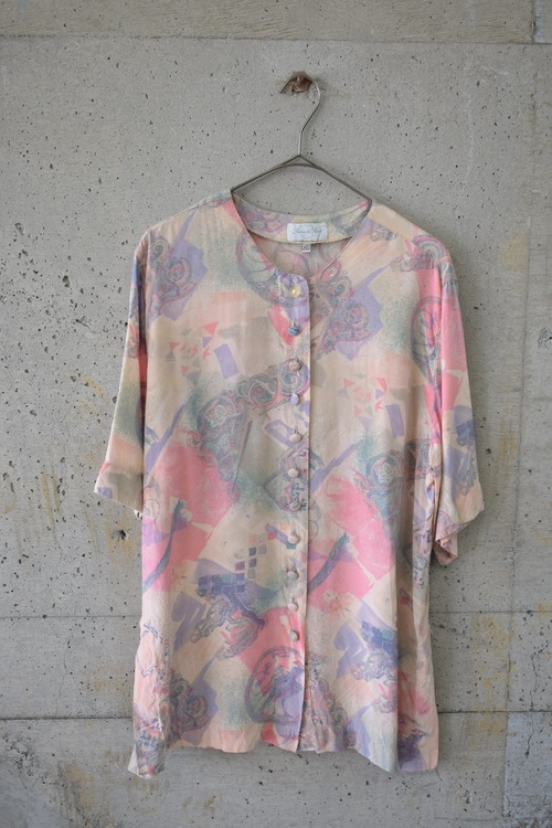 Blouse with numerous pale-toned buttons