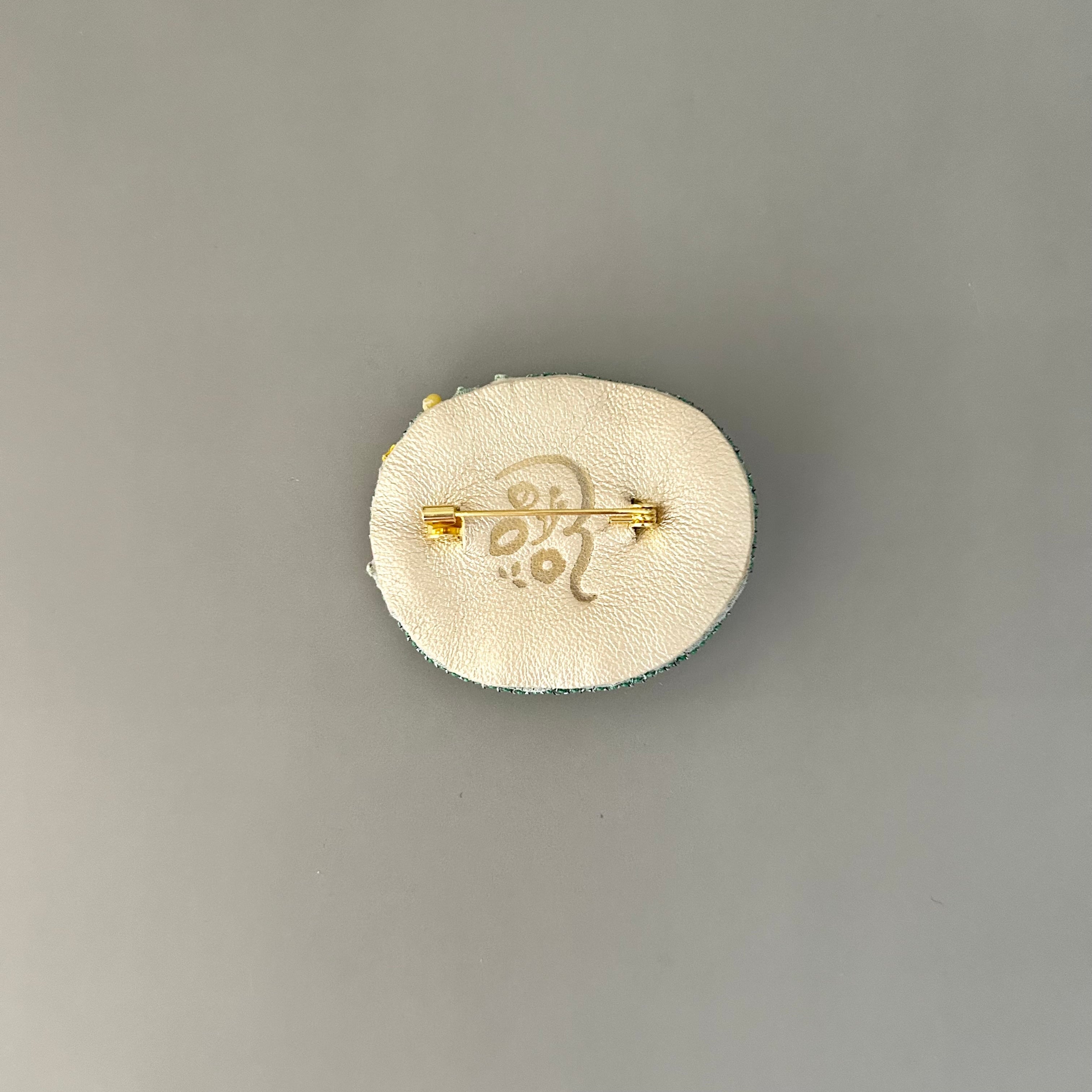 苔リングの中に黄色の菊と松ブローチ | Rika Ogasawara｜ 福岡