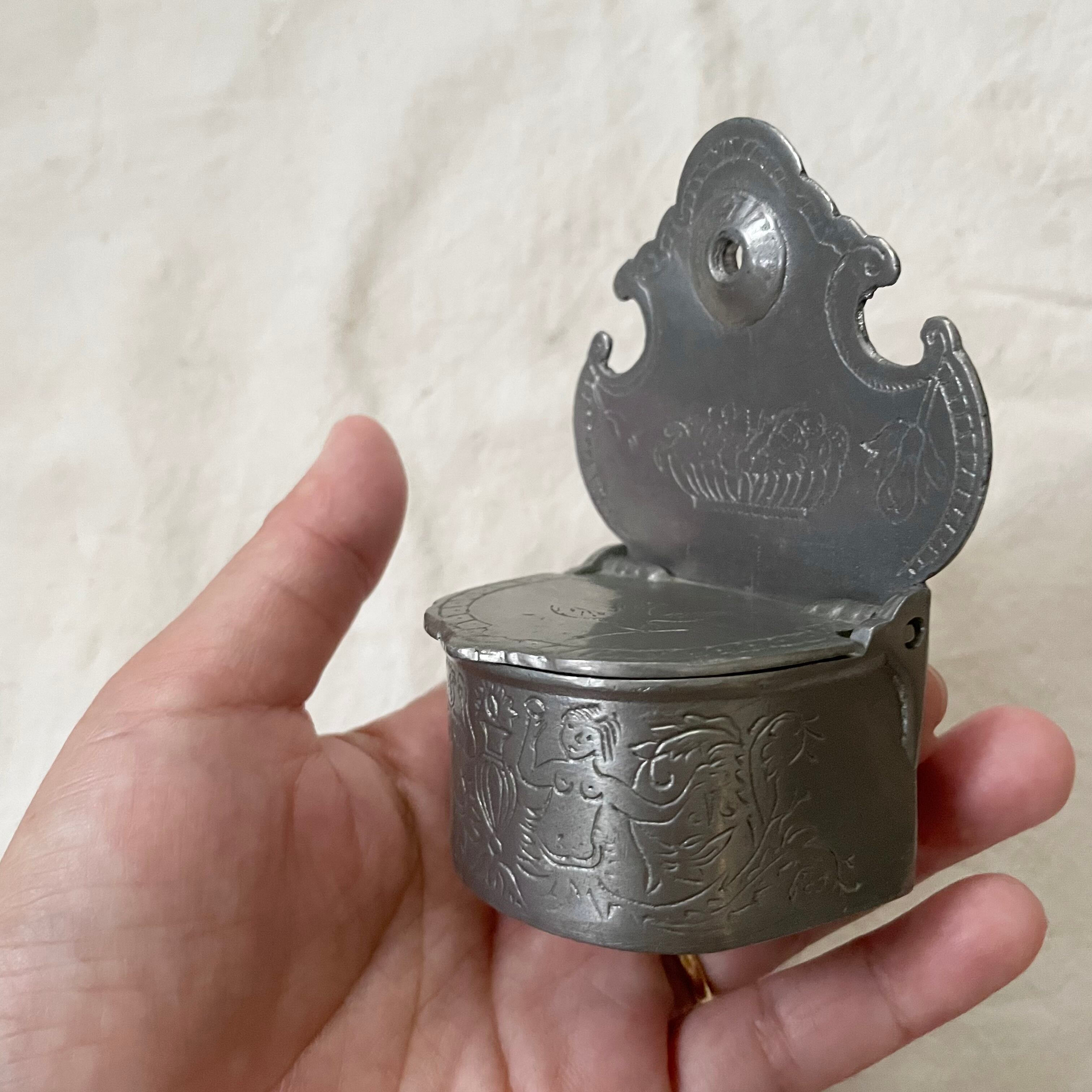 壁に掛けられる金属のいれもの