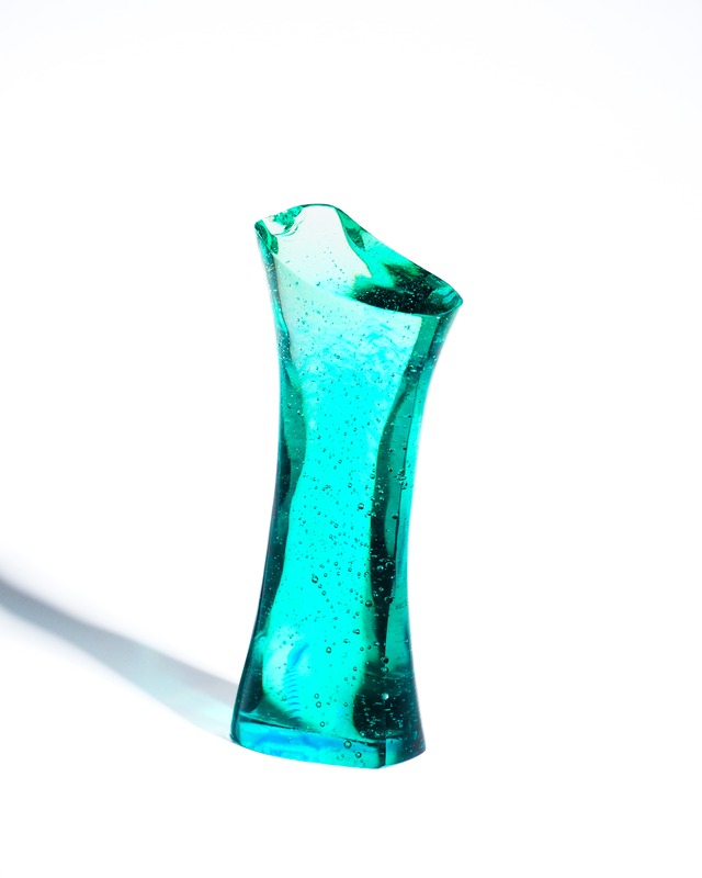 A streamlined, turquoise-blue glass object