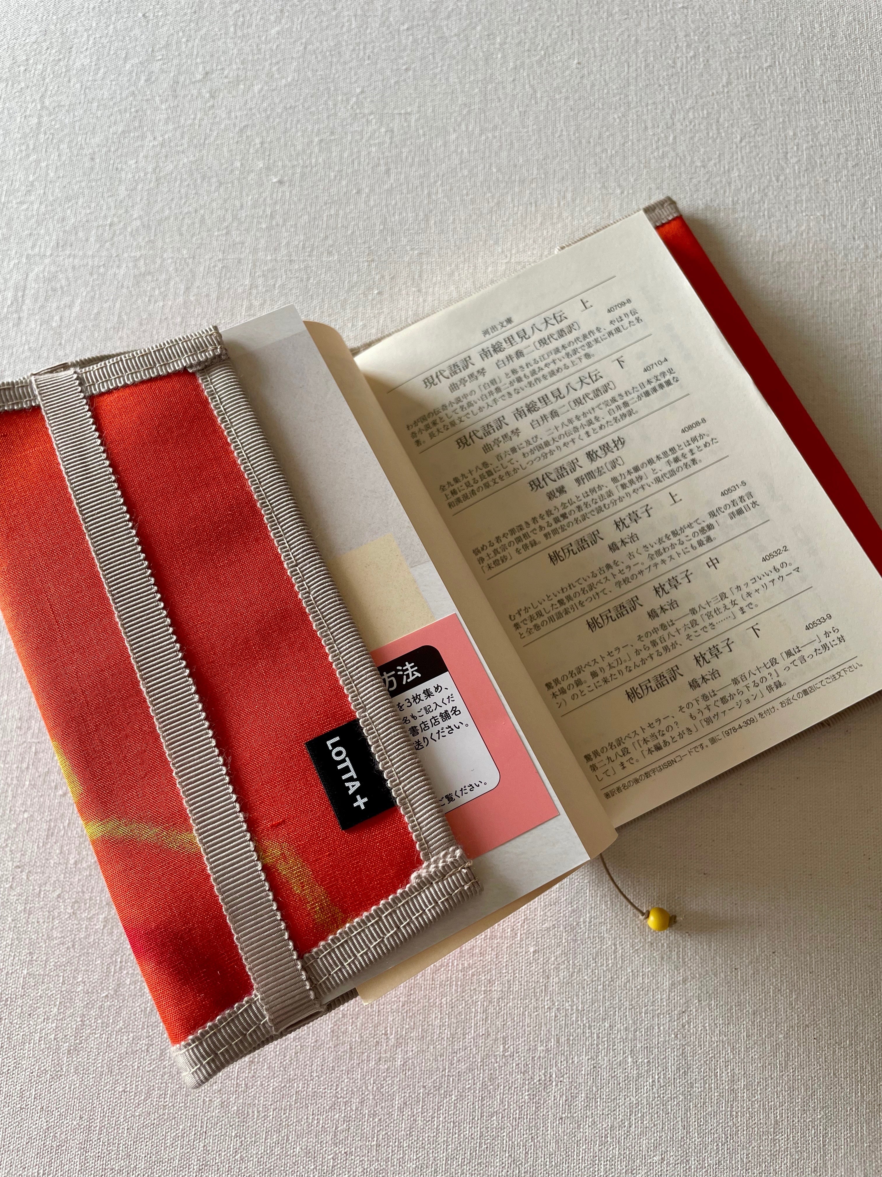 銘仙ワッペンブックカバー・文庫サイズ・オレンジ・リボン・カップ