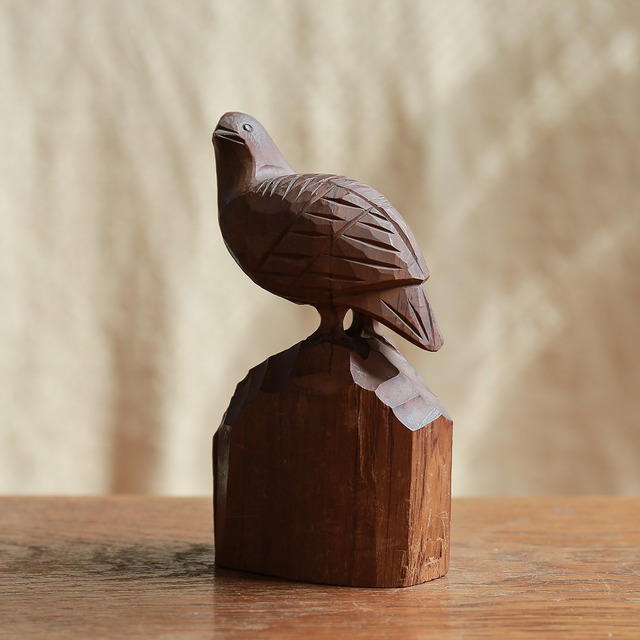 遠くを見つめる、木彫りの鳥