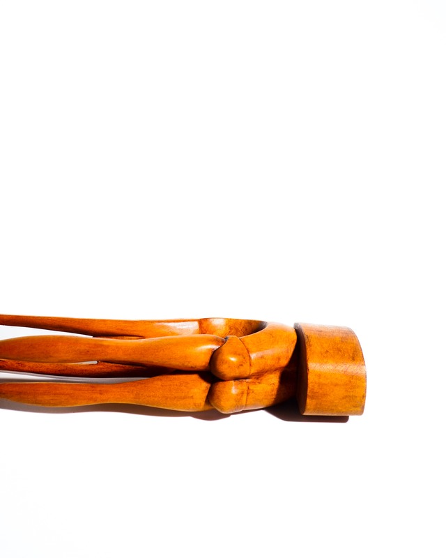 Abstract wooden sculpture of a figure in an acrobatic pose