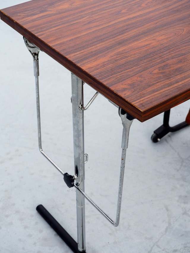 Table with foldable magazine rack, storage compartment, and towel rack