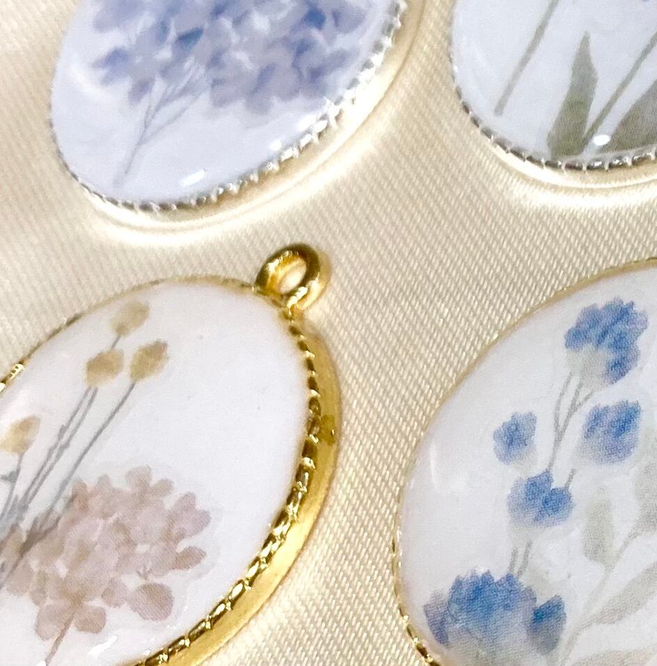 花が描かれた白くて丸いペンダントトップ シックな雰囲気のレジン