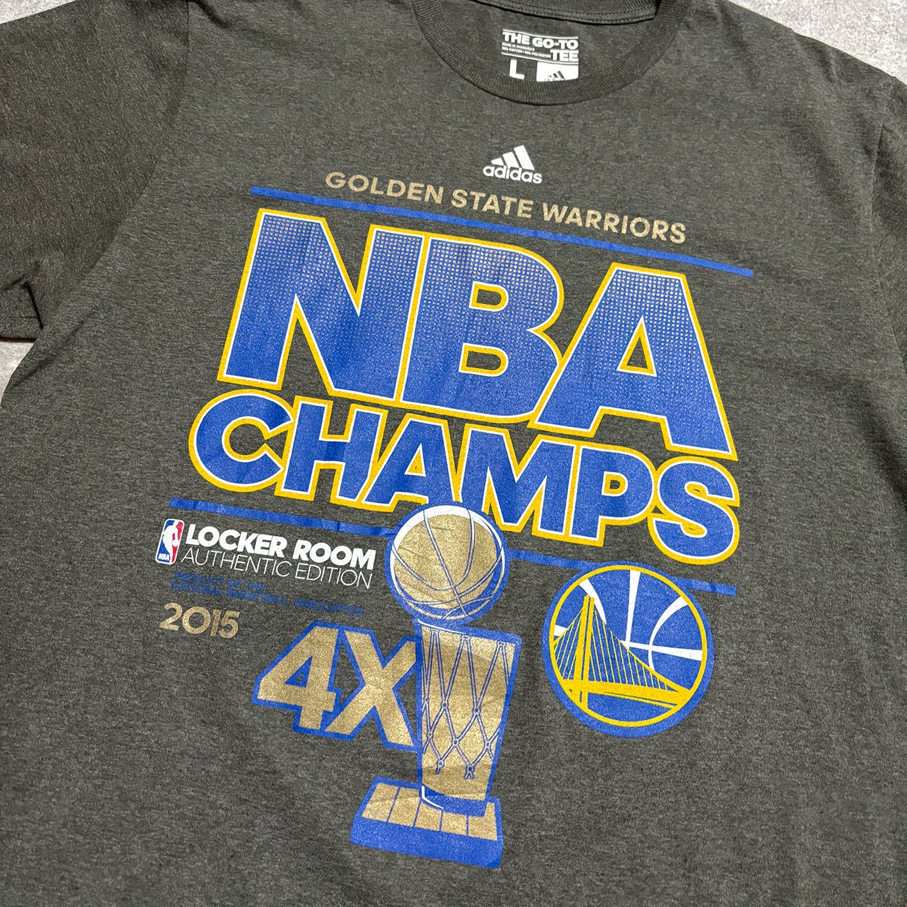 ゴールデンステート・ウォリアーズ 2015 NBAファイナルチャンピオン記念品 Golden State Warriors -2015 NBA CHAMPS- Printed T-Shirt. adidas