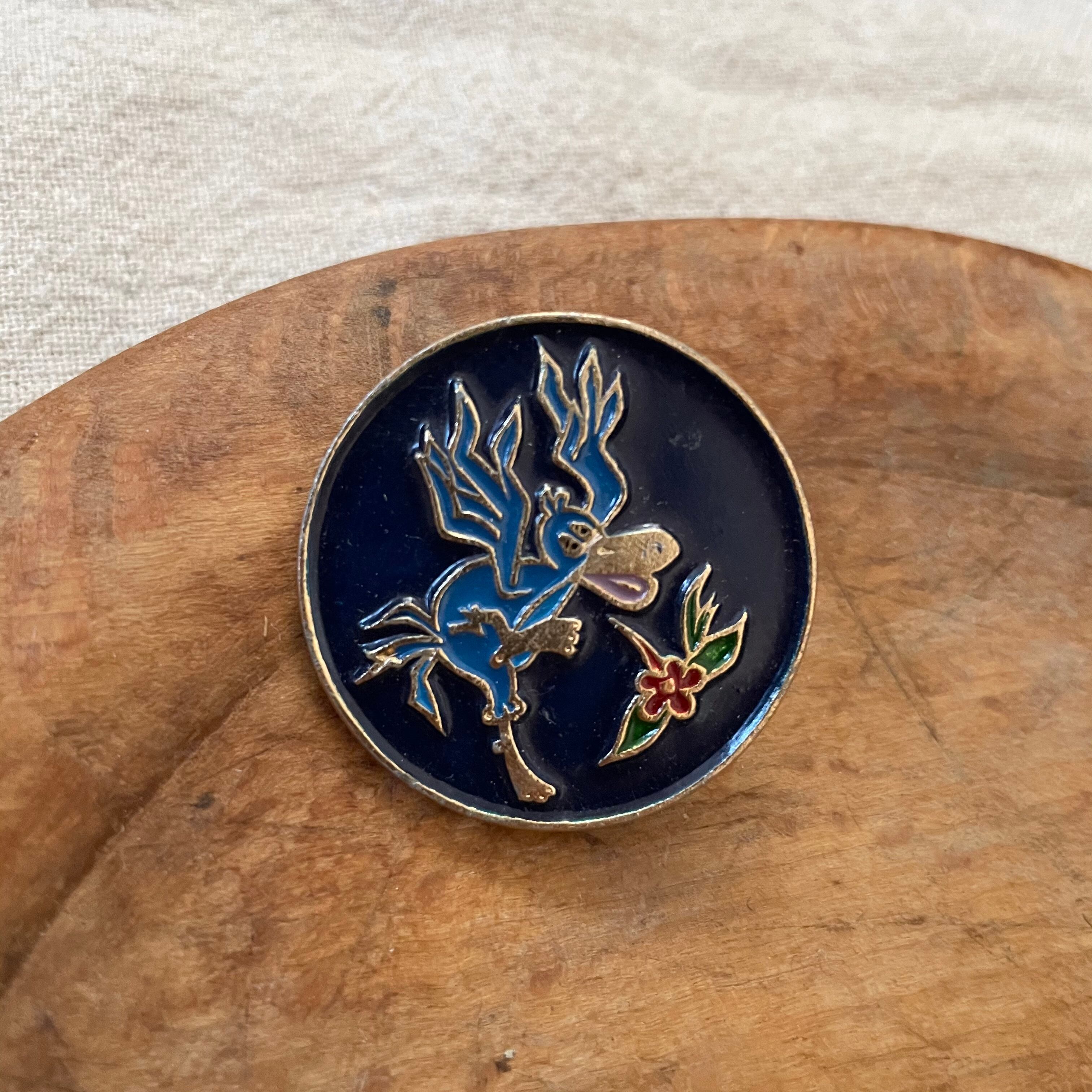 跳ね上がる鳥のピンバッジ