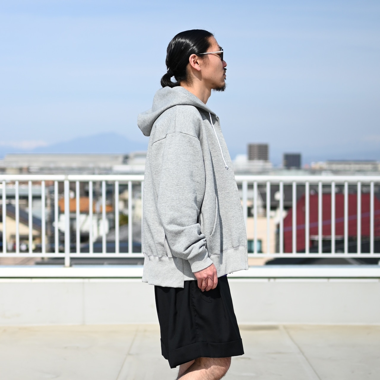 余白のあるシルエットが特徴の新作カバーオールとカフスショーツのセットアップスタイル