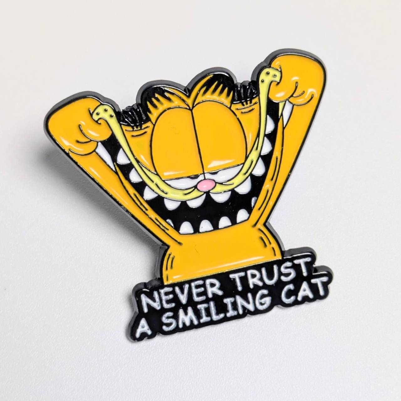 送料無料！ ★ピンズ PINS★ピンバッジ 【 Garfield (ガーフィールド) 】 “ NEVER TRUST A SMILING CAT ”〚アメリカン雑貨 アメトイ〛