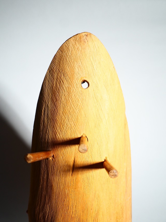 A handmade wooden object with a hook