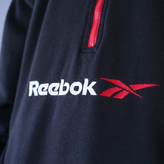 "Reebok" bi-color design over silhouette half-zip sweat pullover