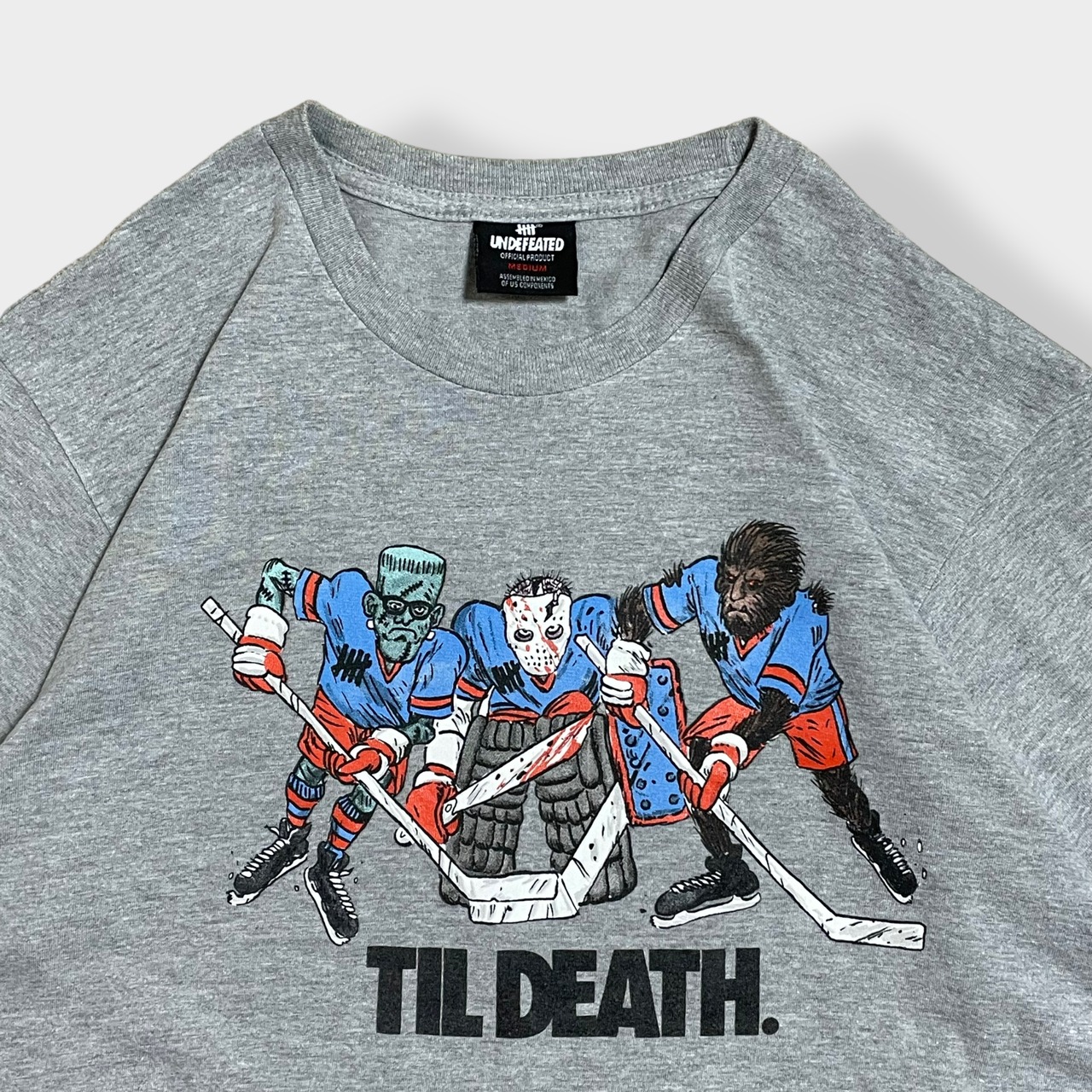 【UNDEFEATED】メキシコ製 プリント TIL DEATH ロゴ Tシャツ イラスト アイスホッケー M 半袖 グレー アンディフィーテッド  us古着