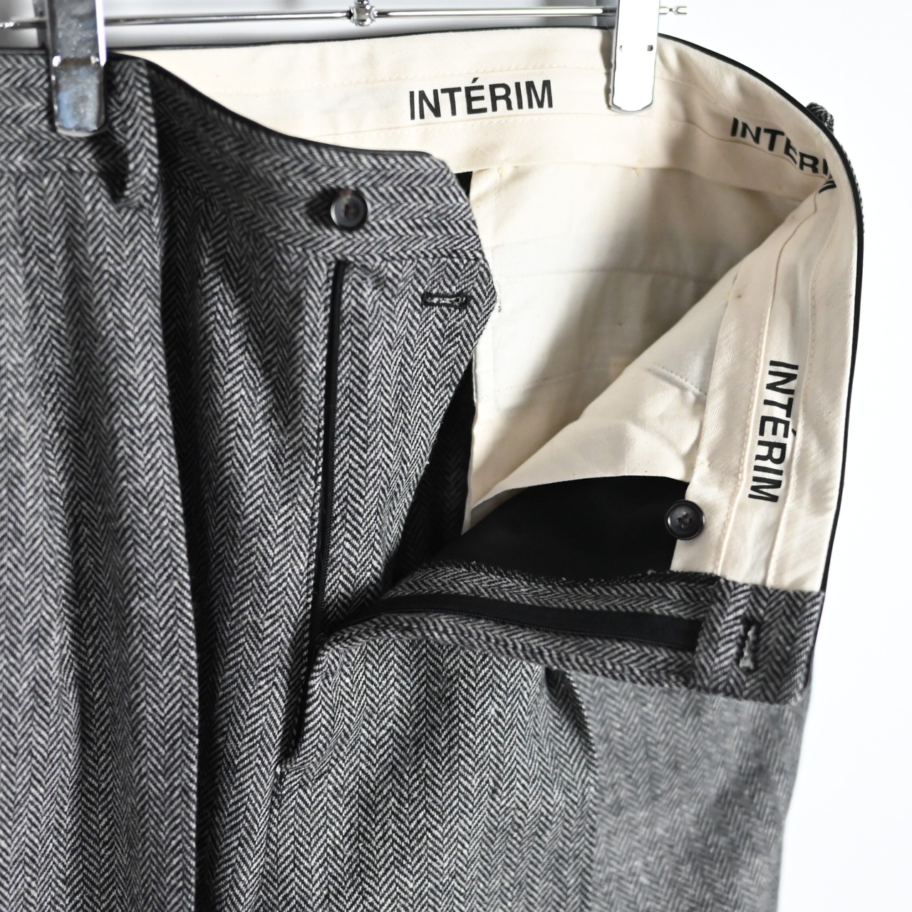 INTERIM / INDIA WOOL CLASSIC HERRINGBONE WITH LEATHER PIPING 2-TUCK STRAIGHT SLACKS