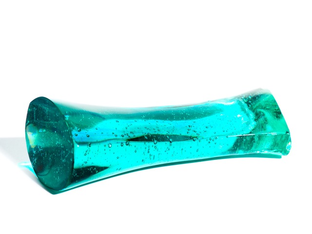 A streamlined, turquoise-blue glass object