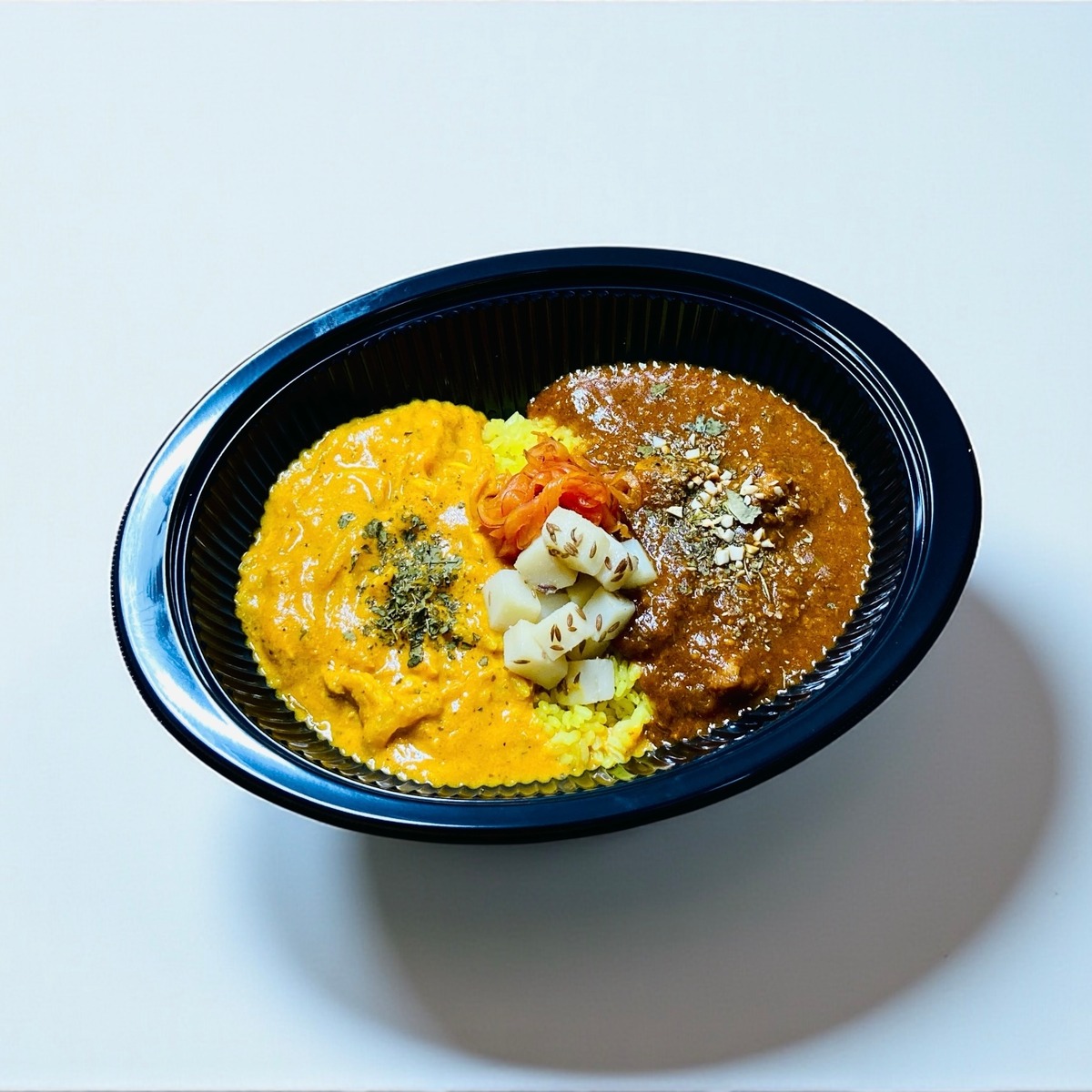 鶏白湯チキンカレーと濃厚バターチキンカレーの合いがけ2種盛りの外観