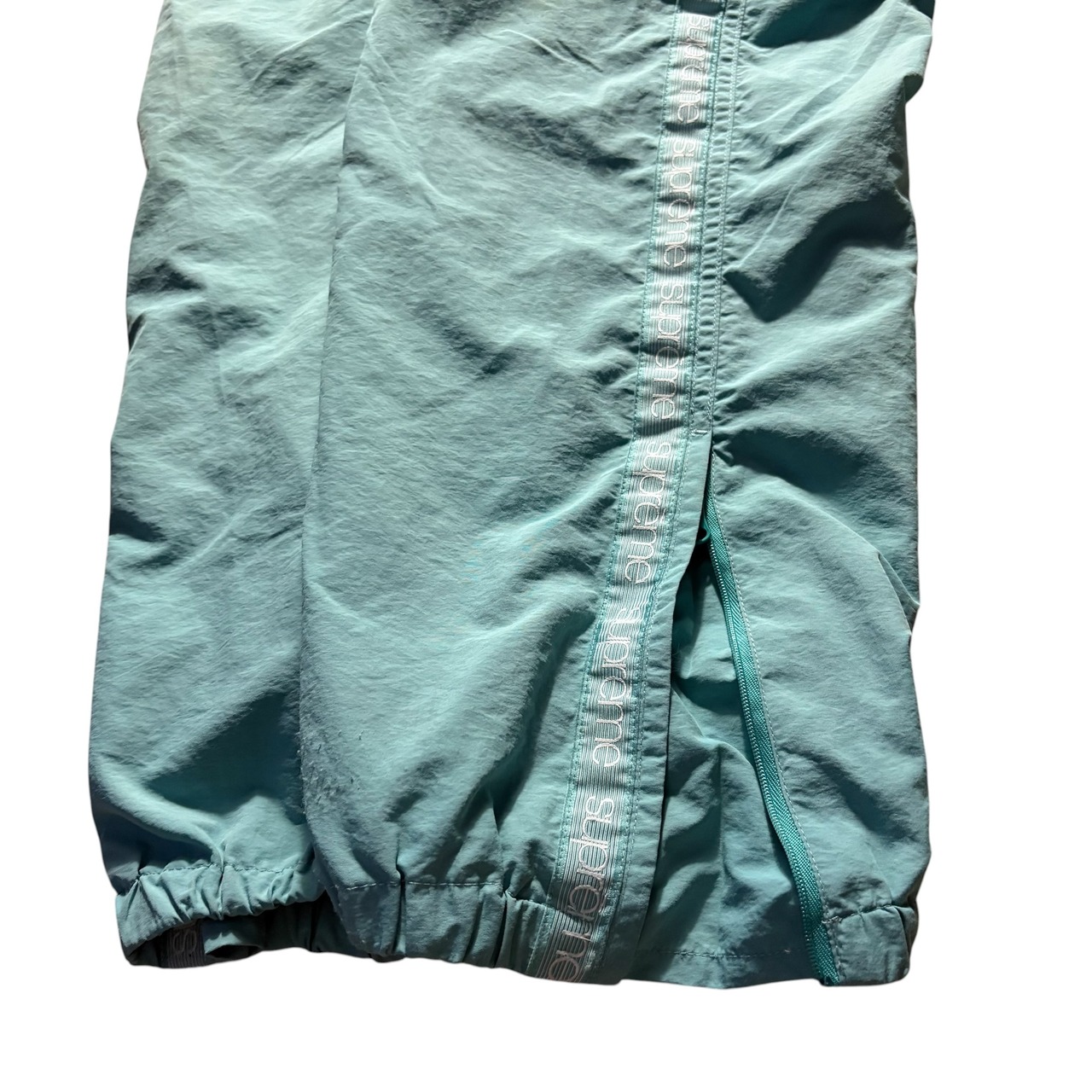 SUPREME logo taping track pants