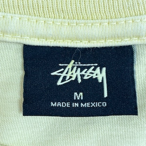 【STUSSY】ワールドツアー Tシャツ MEXICO製 バックプリント ロゴ クルーネック ショーンフォント ライトイエロー SSリンク シャネルロゴ ステューシー world tour tee 半袖 US古着