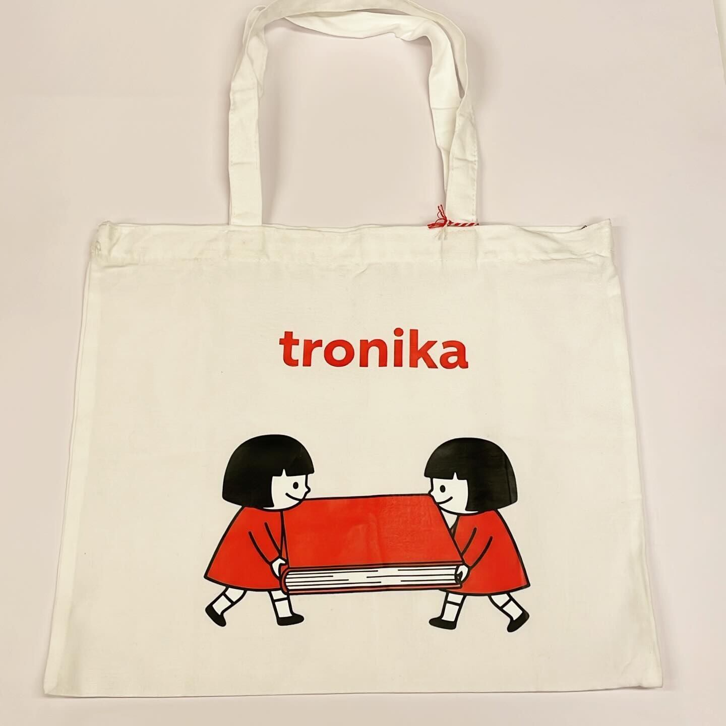 トートバッグ「トロニカ　双子　イラスト　大きい本を運ぶ　白　ジッパー付き」 - 画像1